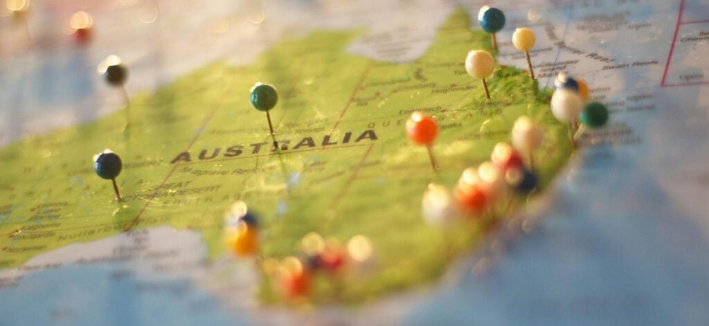 Close-up of a map of Australia with colorful pins marking various cities and destinations.